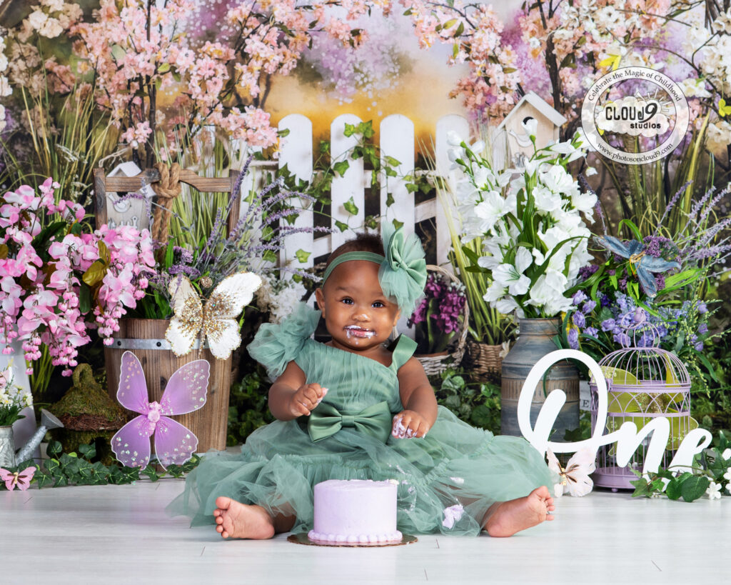 First Birthday Smash Cake Portrait with a baby girl in a garden scene