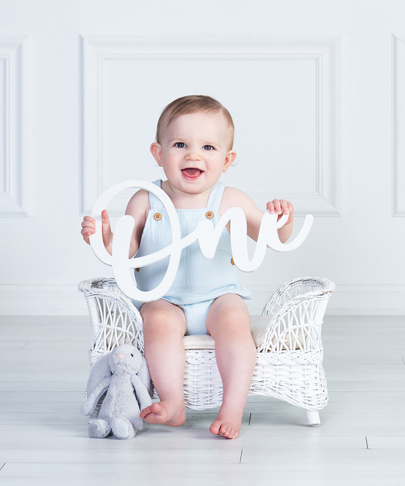 Baby Boy First Birthday Portrait, holding the word ONE