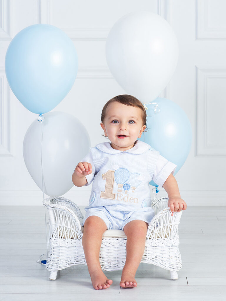 Smiling baby celebrating first birthday with their balloons at Cloud 9 Studios in Wesley Chapel — joyful milestone photo.