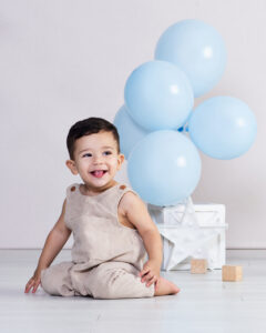 Happy baby boy playing with his balloons at his first birthday session at Cloud 9 Studios in Wesley Chapel, FL