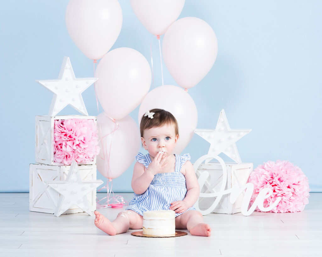 Baby reacting to cake smash moment in first birthday session at Cloud 9 Studios.