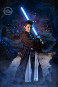 A boy dressed as a jedi knight ready to take on the dark side in his fighting stance with a light saber, in our studio in Wesley Chapel, Florida just north of Tampa