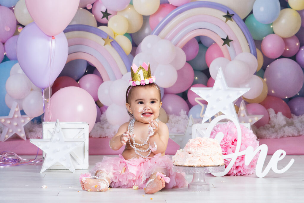 A baby girl covered in frosting from smashing her first birthday cake at the studio in Wesley Chapel, Florida