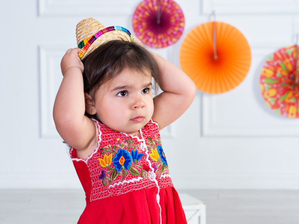 A two year old with her pouty face on in her Mexican styled dress and studio setting at Cloud 9 Studios in Wesley Chapel, Florida
