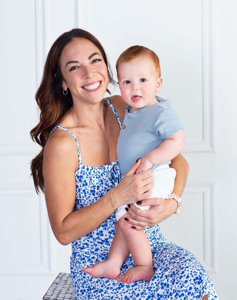a mom smiling with joy as she holds her one year old son at Cloud 9 Studios in Wesley Chapel, Florida