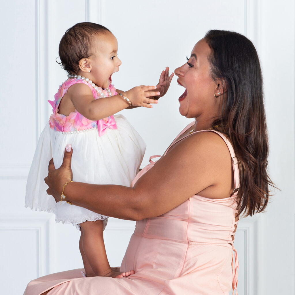 a mom excited and making faces with her baby girl as they celebrate her first birthday together at Cloud 9 Studios in Wesley Chapel, Florida