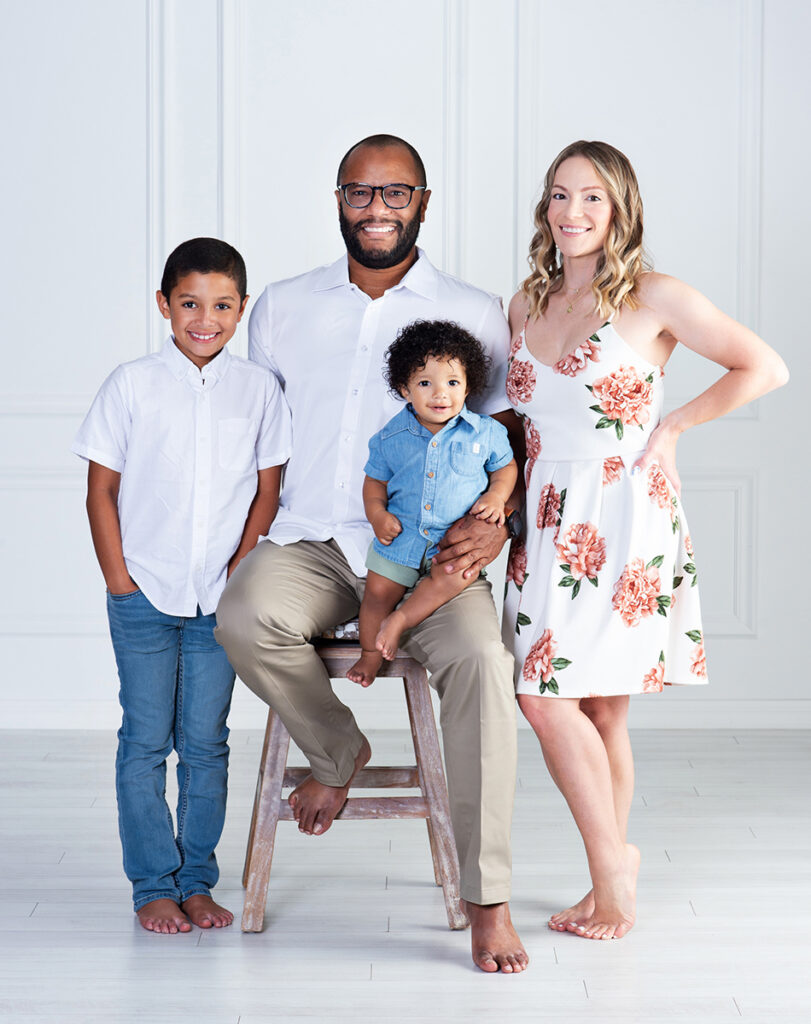 a mom and ad happy and laughing with their two sons as the celebrate the baby's first birthday at Cloud 9 Studios in Wesley Chapel, Florida
