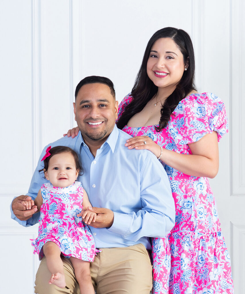 a mom, dad and baby girl snuggled together for a family portrait showing how they celebrate the first birthday together at Cloud 9 Studios in Wesley Chapel, Florida
