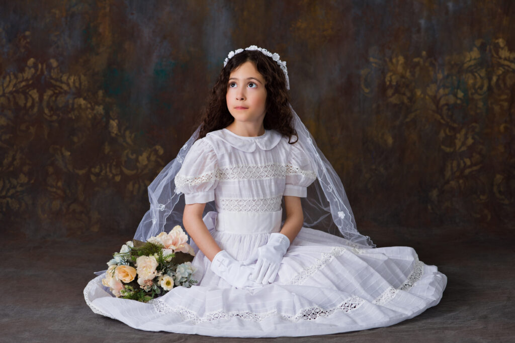 A young girl looking in awe up to heaven as she sits for her First Communion Portrait at Cloud 9 Studios in Wesley Chapel, Florida