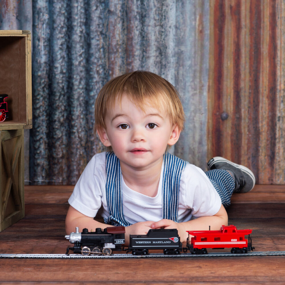 Two year old boy playing with his favorite trains at Cloud 9 Studios for a portrait in Wesley Chapel, Florida