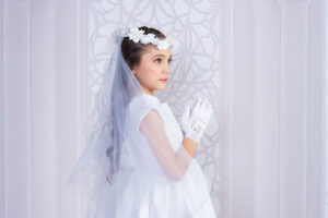 A girl praying during her First Communion Portrait at Cloud 9 Studios in Wesley Chapel, Florida