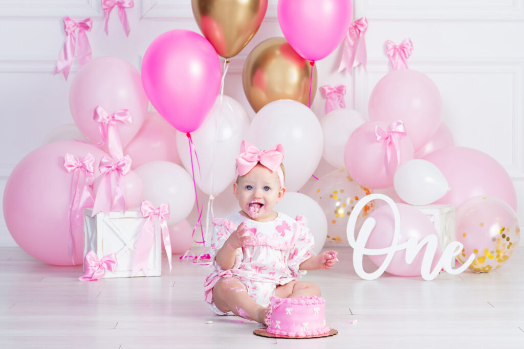 baby girl eating her birthday cake during a first birthday smash cake session at cloud 9 studios in Wesley Chapel, Florida