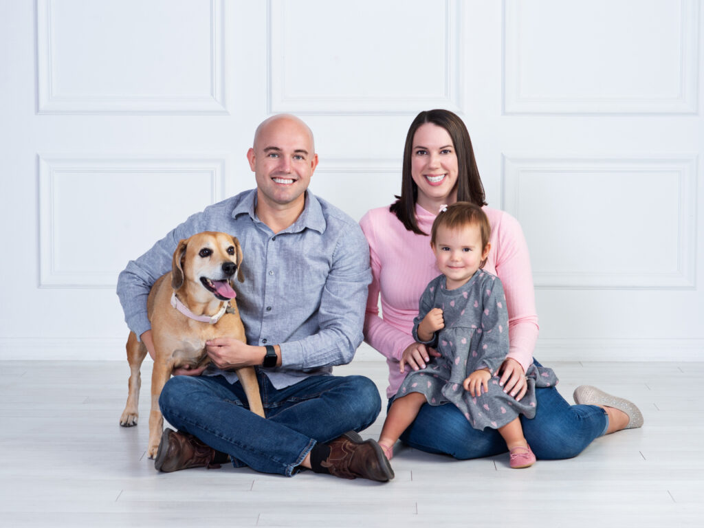 Family portrait with child and dog wearing cool shades of grey and pink in Wesley Chapel, Florida