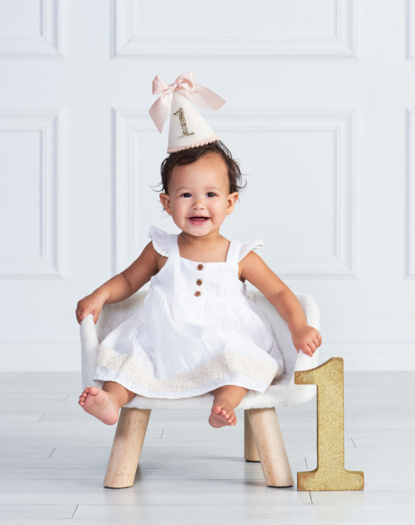 Smiling one-year-old baby in a simple classic portrait at Cloud 9 Studios