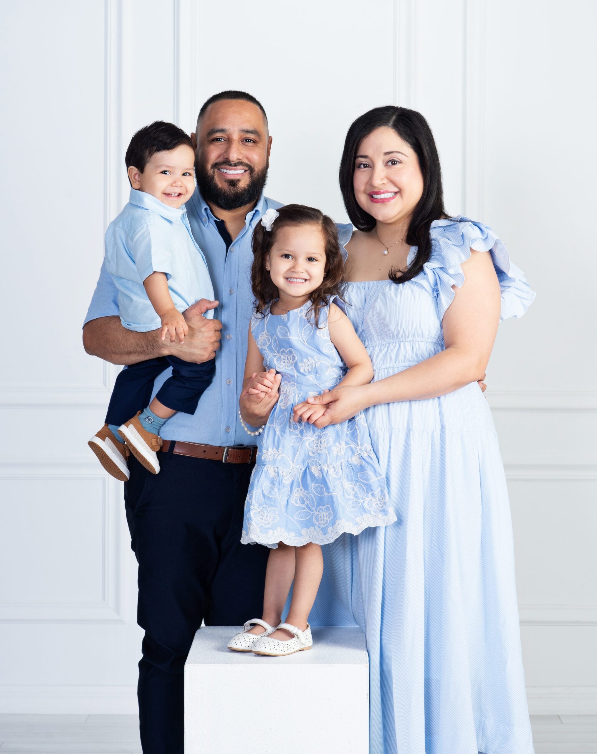 Family of four smiling together during a family portrait session at Cloud 9 Studios