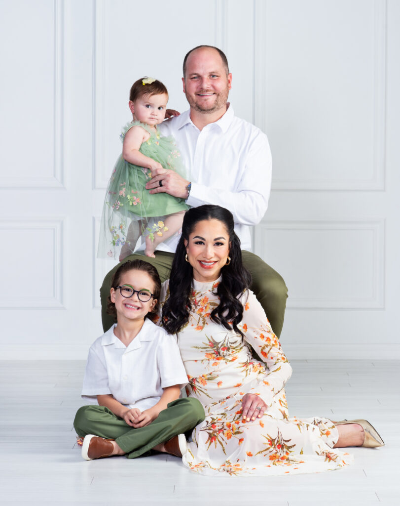 Mom and Dad holding their baby during a first birthday family portrait