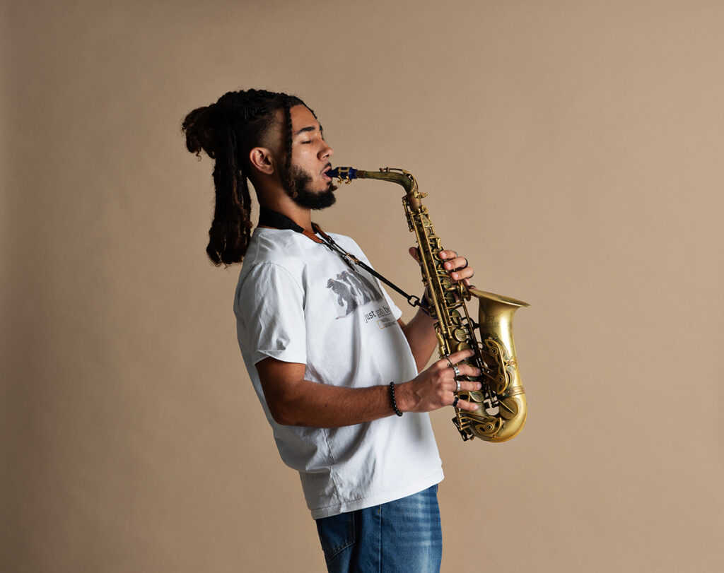 High school senior JB posing with the saxophone he played in school band