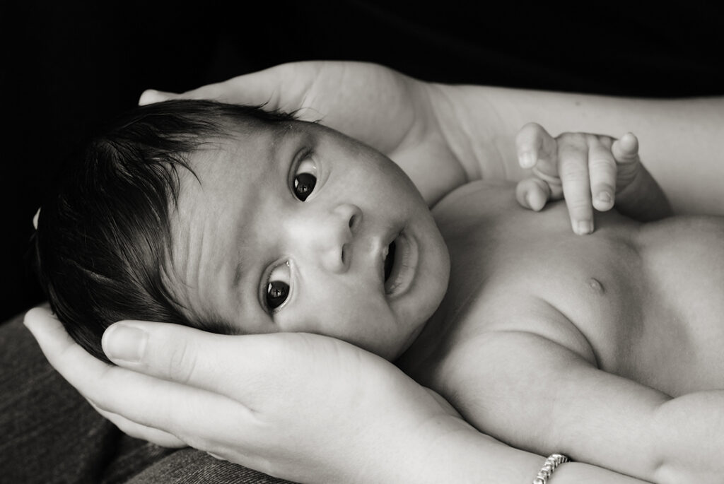 Newborn JB photographed in his mom's hands