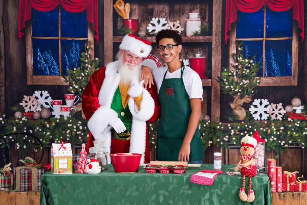 An older JB standing beside Santa as part of his family's annual Christmas tradition
