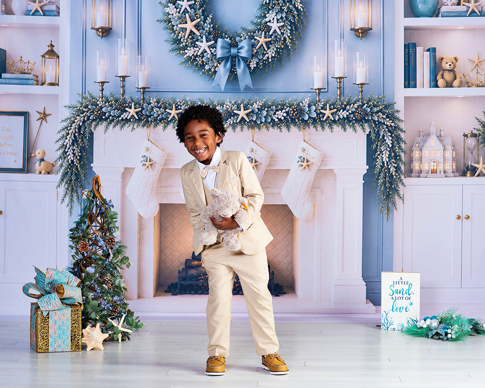 boy laughing with his teddy bear for a christmas portrait in a coastal florida setting
