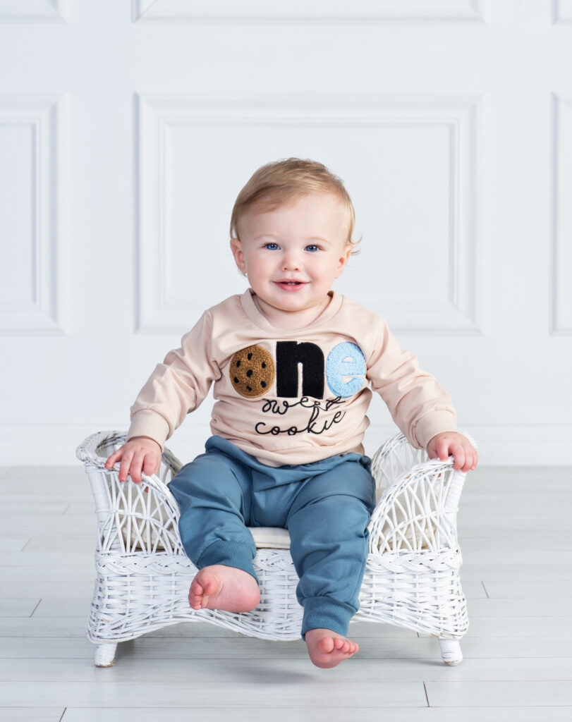 Smiling one-year-old baby boy in a simple classic portrait at Cloud 9 Studios
