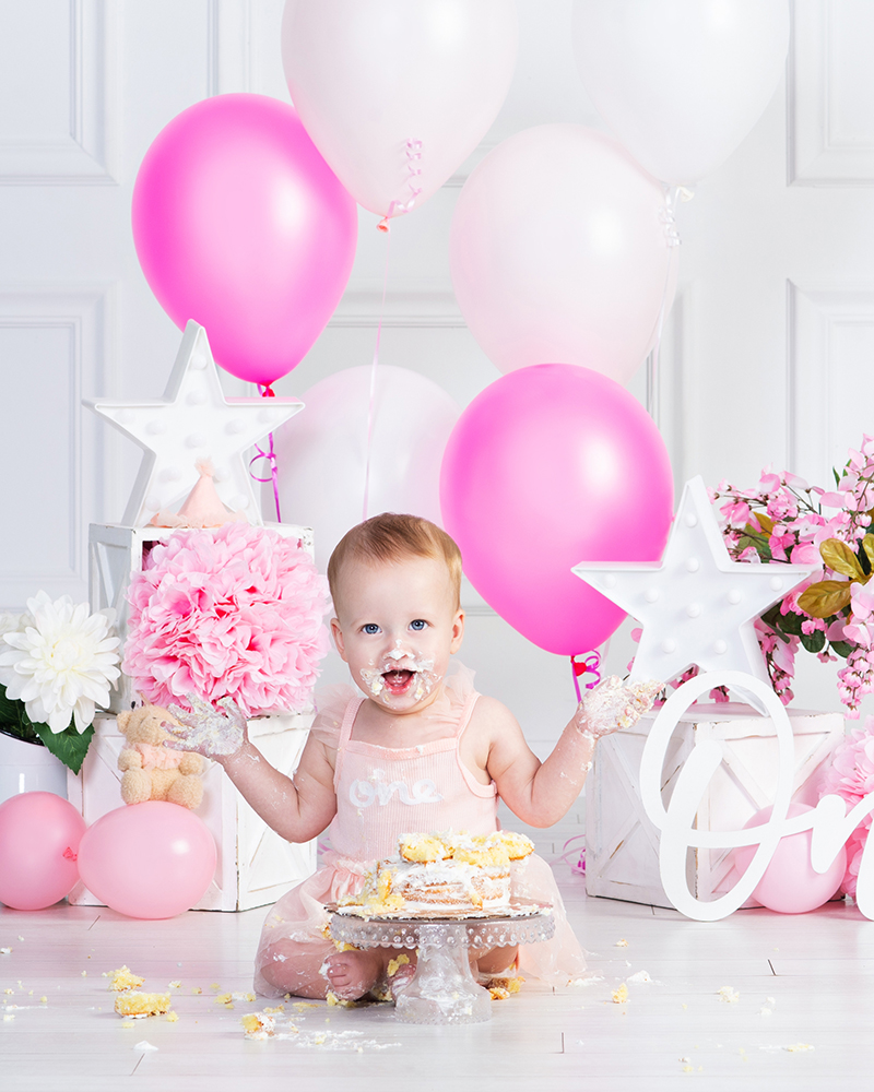 baby girl smashing her first birthday cake at Cloud 9 Studios