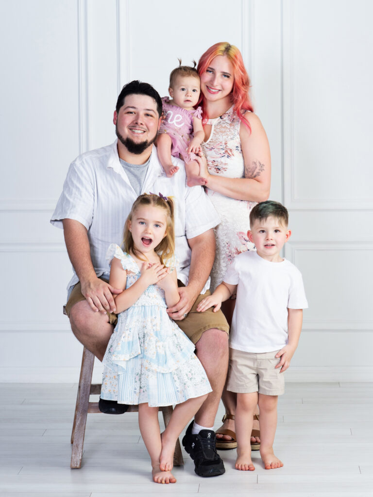 Family with their children during a baby's first birthday portrait session