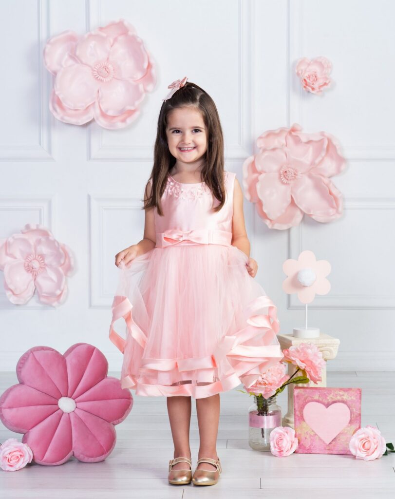 Five-year-old girl surrounded by pink flowers during her birthday portrait session at Cloud 9 Studios in Wesley Chapel, Florida.