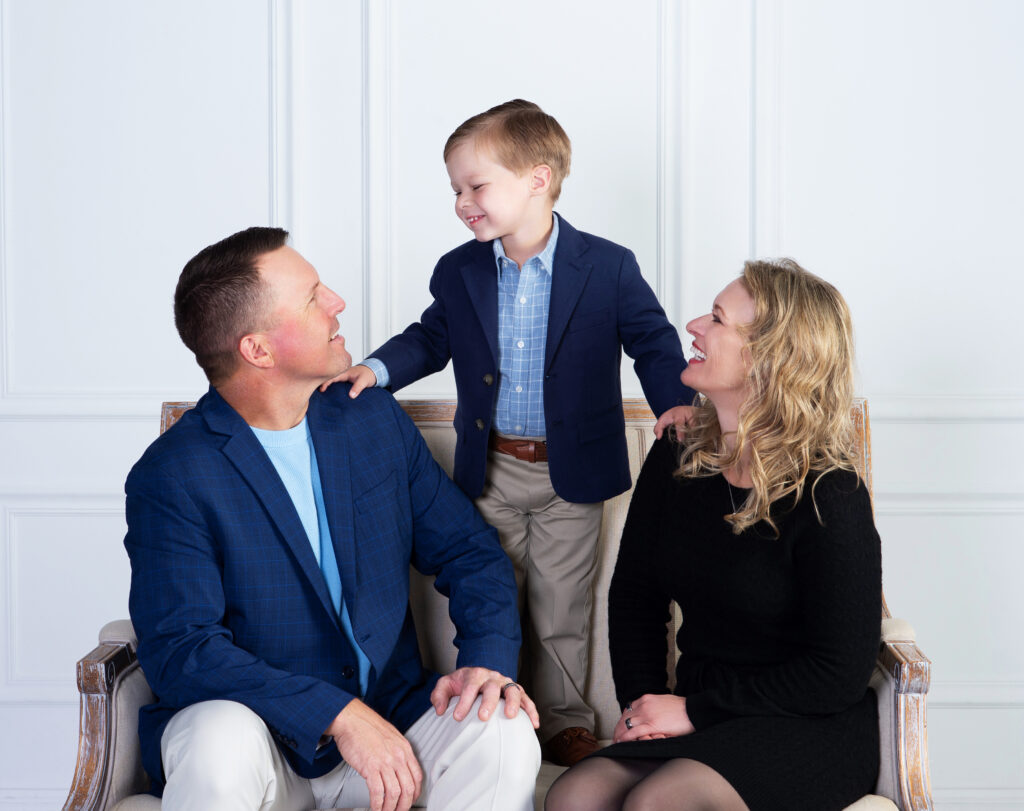 Parents smiling at their young son during a natural family portrait at Cloud 9 Studios in Wesley Chapel, Florida