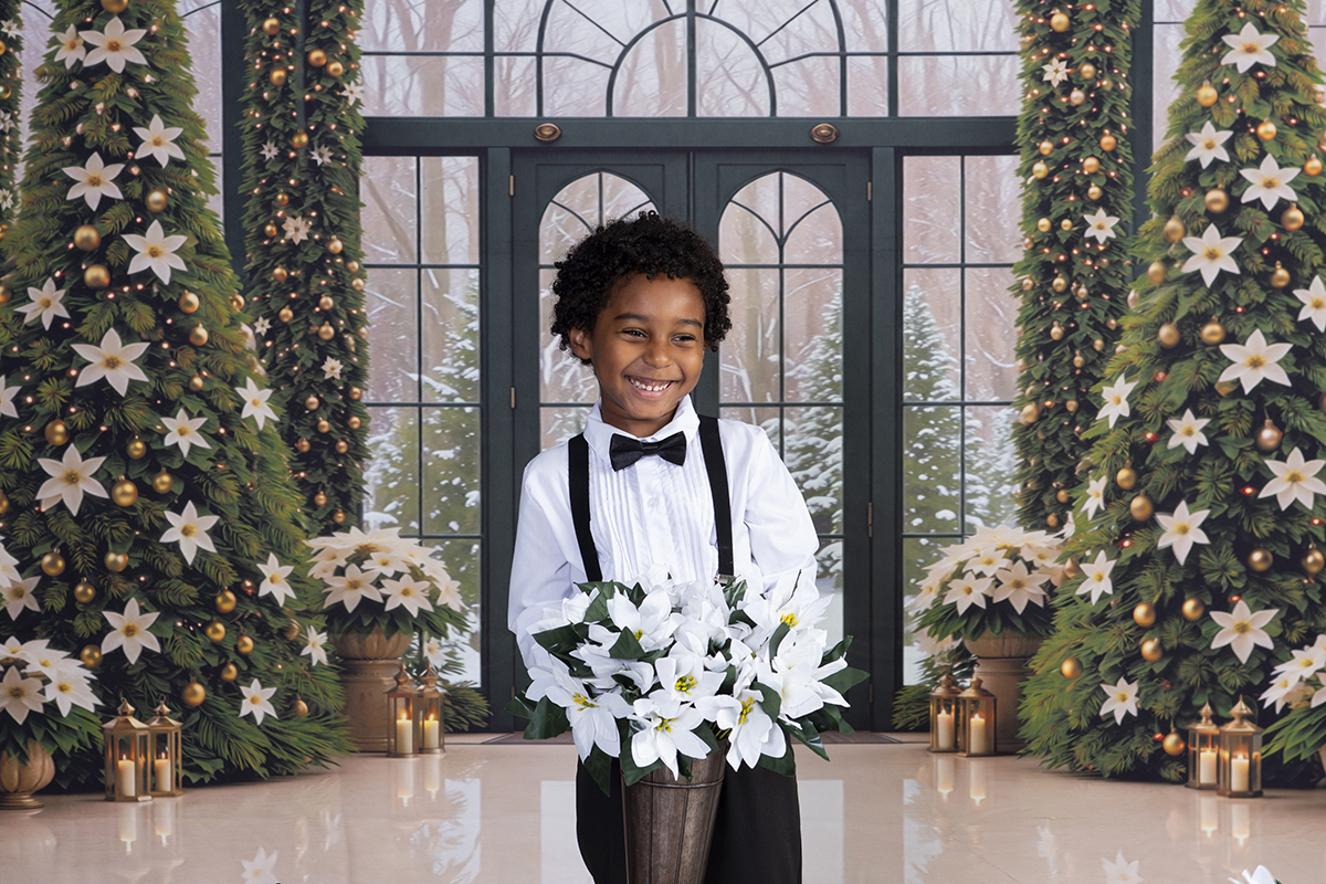 boy holding white poinsettias and laughing during a Christmas Portrait session