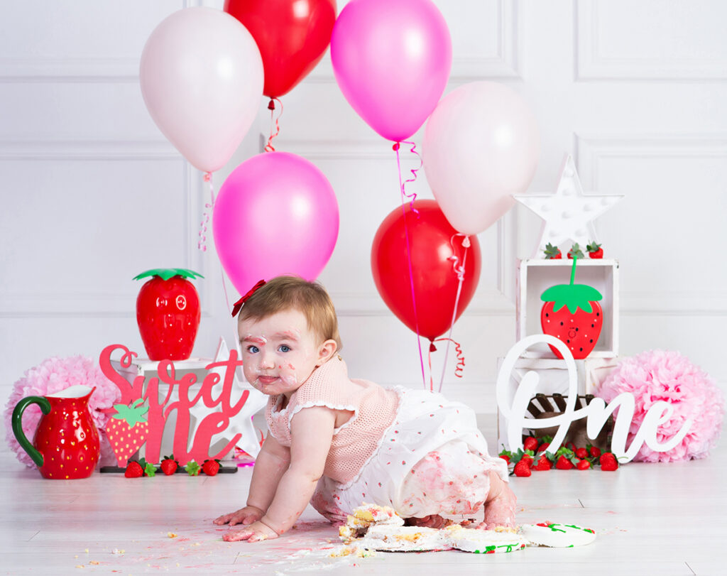 One-year-old girl crawling away from her birthday cake during her cake smash portraits